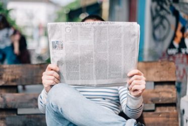 Person Reading How the News Media Makes Money